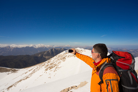 man in a winter hike in the mountains with a backpack.の写真素材