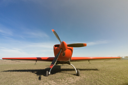 Red sport aircraft at the airport on a sunny day.の写真素材