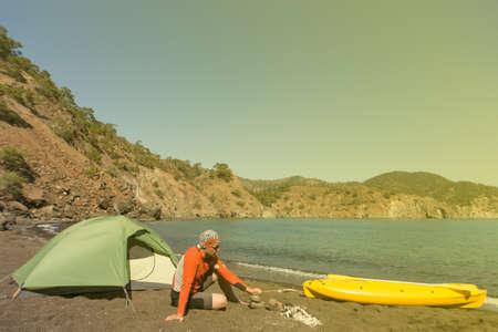 The man on the beach with kayak and tent on a sunny day.の写真素材