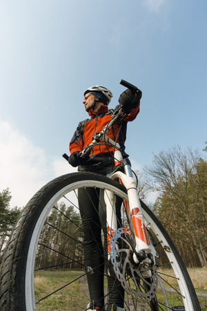 Male cyclist traveling through the woods in early spring.の写真素材