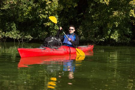 The man is kayaking on the river.の写真素材