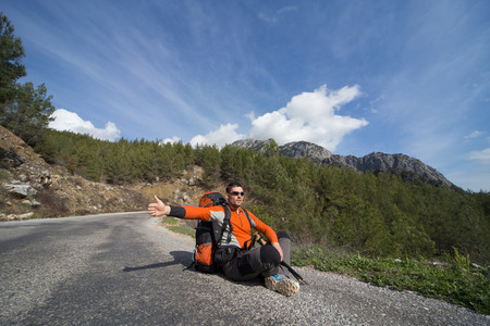 A man with a backpack on the road traveling.の写真素材