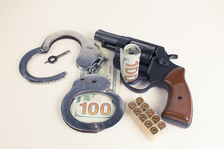 Dollars handcuffs handgun cartridges on a white background.の写真素材