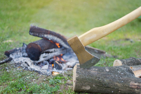 Camping in the woods with a fire ax in the summer.の写真素材