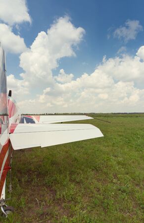 The aircraft is standing on the grass against the blue sky.
