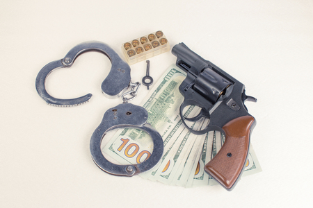 Pistol, handcuffs ammo and money on a white background.の写真素材