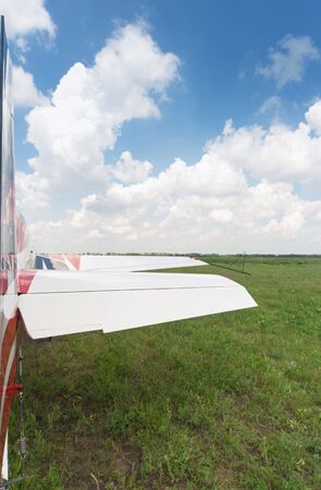 The aircraft is standing on the grass against the blue sky.の写真素材