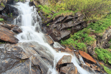 Beautiful cascading full-flowing waterfall in the mountains.の写真素材