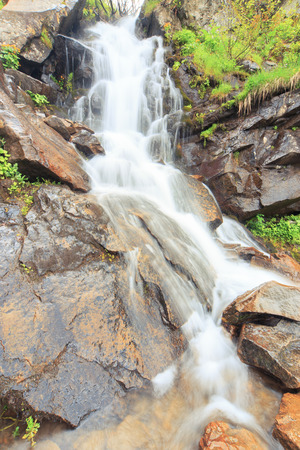 Beautiful cascading full-flowing waterfall in the mountains.の写真素材