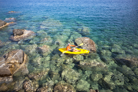 A man traveling by canoe along the coast in the summer.の写真素材