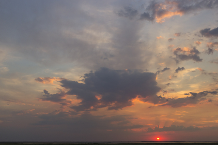 Beautiful sunset red sun in the clouds.の写真素材