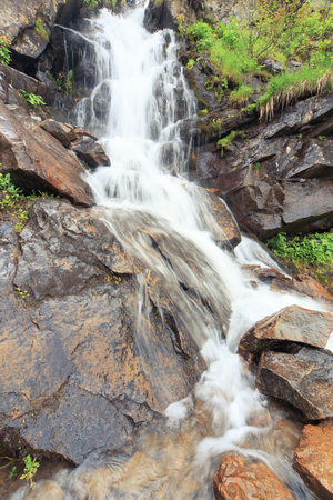 Beautiful cascading full-flowing waterfall in the mountains.の写真素材