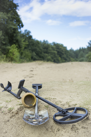 Search for treasure using a metal detector and shovel.の写真素材