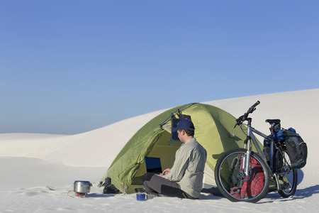 Travel by bike in the desert with a backpack and tent.の写真素材