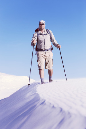 The journey in the desert dunes with white on a backpack.の写真素材