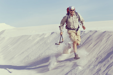 The journey in the desert dunes with white on a backpack.の写真素材