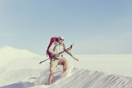 The journey in the desert dunes with white on a backpack.の写真素材