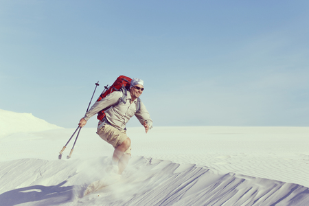 The journey in the desert dunes with white on a backpack.の写真素材