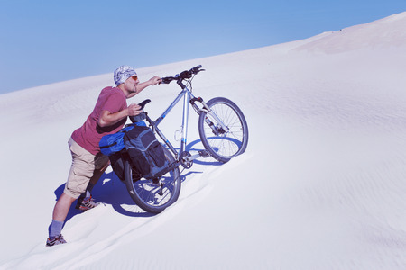 Travel by bike in the desert with a backpack and tent.の写真素材