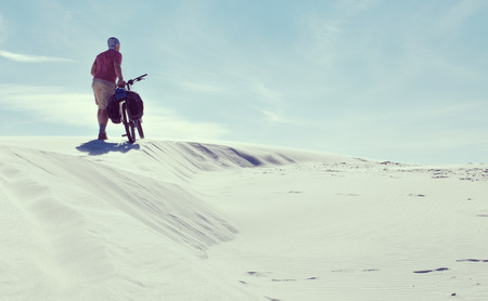 Travel by bike in the desert with a backpack and tent.の写真素材
