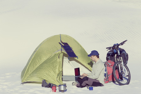 Travel by bike in the desert with a backpack and tent.の写真素材