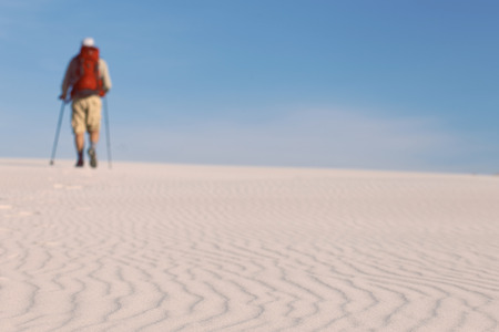 The journey in the desert dunes with white on a backpack.の写真素材