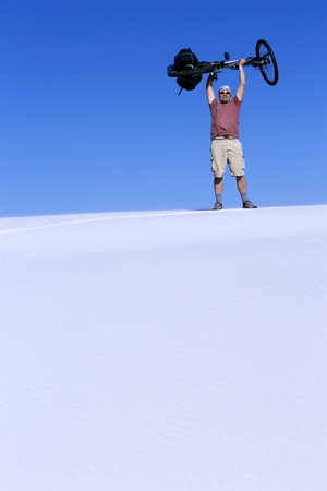 Travel by bike in the desert with a backpack and tent.の写真素材