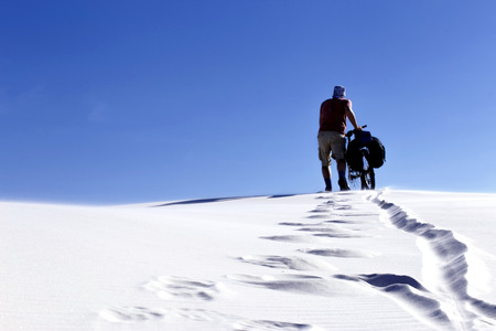 Travel by bike in the desert with a backpack and tent.の写真素材