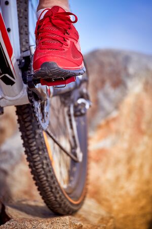 Cyclist in helmet with mountain bike in the mountains.