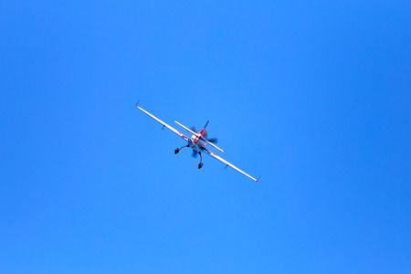 Flight of a sport aircraft against a blue sky.