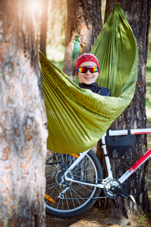 Rest in a hammock after a cycling adventure in the forest.の写真素材
