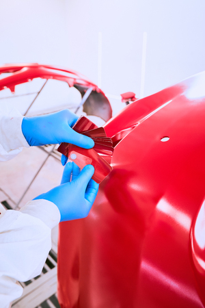 Painting the car's bumper red on the service.の写真素材