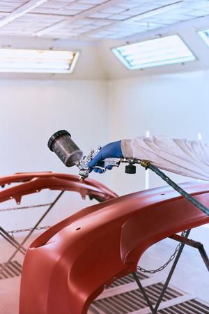 Painting the car's bumper red on the service.の写真素材