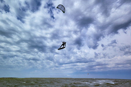 Man riding a kite surfing on the waves in the summer.の写真素材