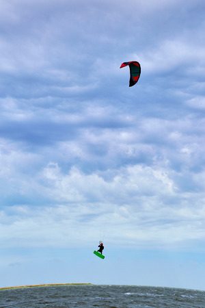 Man riding a kite surfing on the waves in the summer.の写真素材