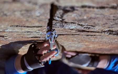 A woman climber climbs a complex rock.