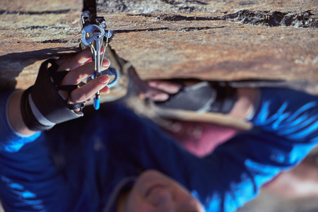 A woman climber climbs a complex rock.の写真素材