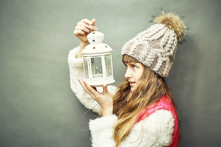 A girl with a lamp inside which is burning a candle.の写真素材