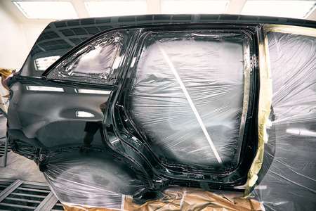 Painting the car in black color in the paint chamber on the service.の写真素材