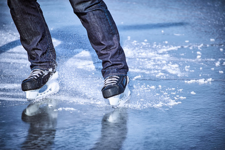 The guy rides on skates on ice in the winter.