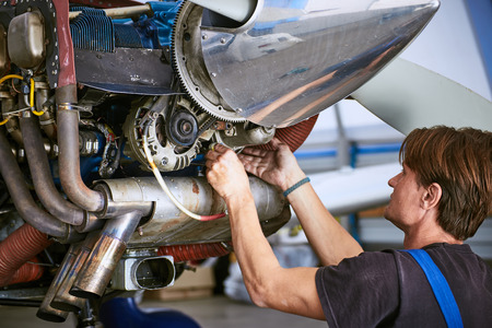 Removal and repair of an engine starter of an airplane by a service worker.の写真素材