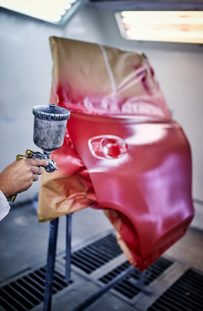 Painting the car door in red color in the painting chamber.の写真素材