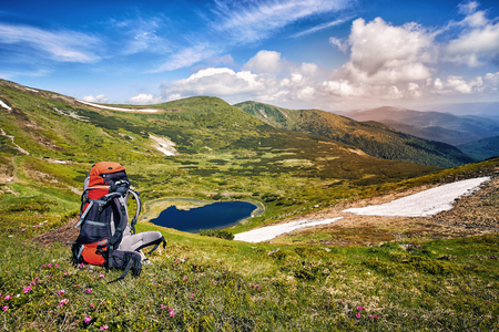 Summer hike in the mountains with a backpack and tent along the path to the top.の写真素材