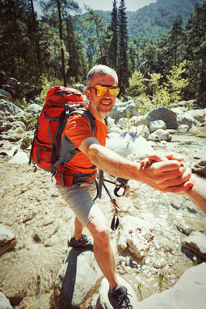 A helping hand for a girl high mountains in a hike.の写真素材