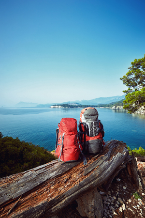 Two backpacks in the camp on a hike along the coast in the summer.の写真素材