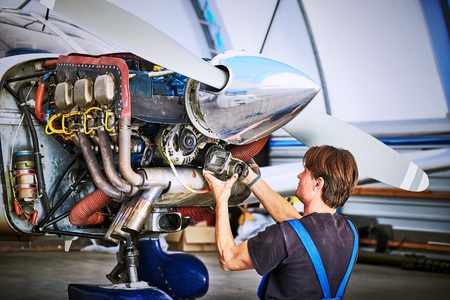 Removal and repair of an engine starter of an airplane by a service worker.の写真素材