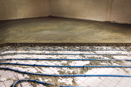 Laying pipes for floor heating at the construction site of the house.の写真素材
