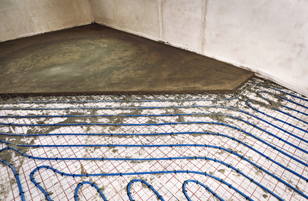 Laying pipes for floor heating at the construction site of the house.の写真素材