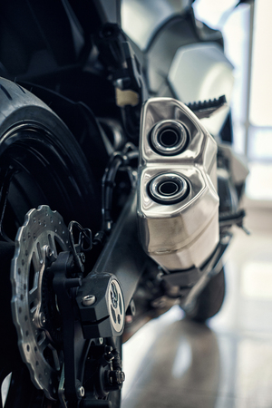 Detail of a motorcycle rear chain with exhaust pipes. Rear view of a motorcycle with the focus on chain.の写真素材