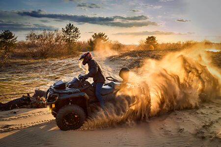 Racing in the sand on a four-wheel drive quad.の写真素材